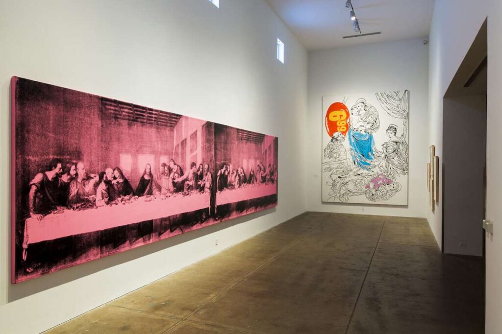 A gallery space displays iconic Andy Warhol artworks, including a pink-toned 'Last Supper' and a vibrant piece featuring the number '69', symbolizing the artist's influence on pop art.