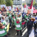 Lithuanian protesters, clad in green vests and holding portraits and signs, demonstrate for democratic reform and transparency in the country.
