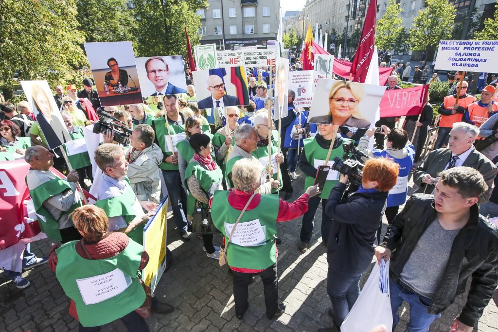 Lithuanian protesters, clad in green vests and holding portraits and signs, demonstrate for democratic reform and transparency in the country.
