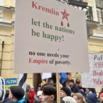 Protesters in Estonia hold signs criticizing Russian aggression and the Kremlin, reflecting national frustration over foreign policy and regional security concerns.