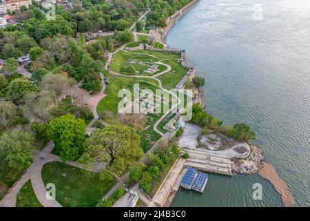 A serene aerial view of a riverside park in Sofia, contrasting with the city's recent anti-corruption protests demanding justice for businessman Pevski.
