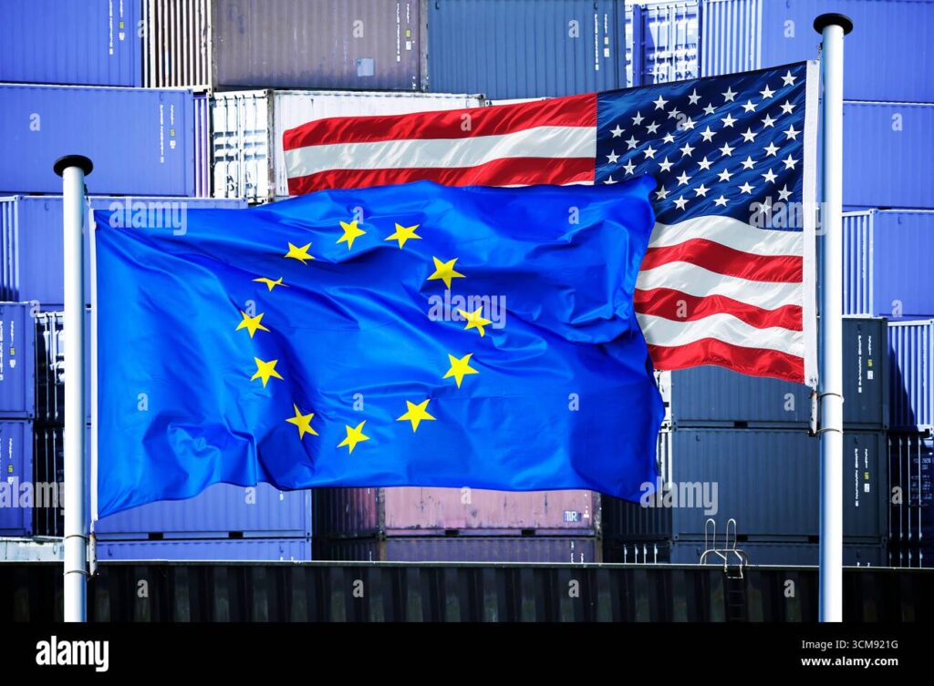 Symbolizing global trade tensions, the EU and U.S. flags flutter together against a sea of shipping containers, as economic disputes like Trump's Greenland tariffs escalate.