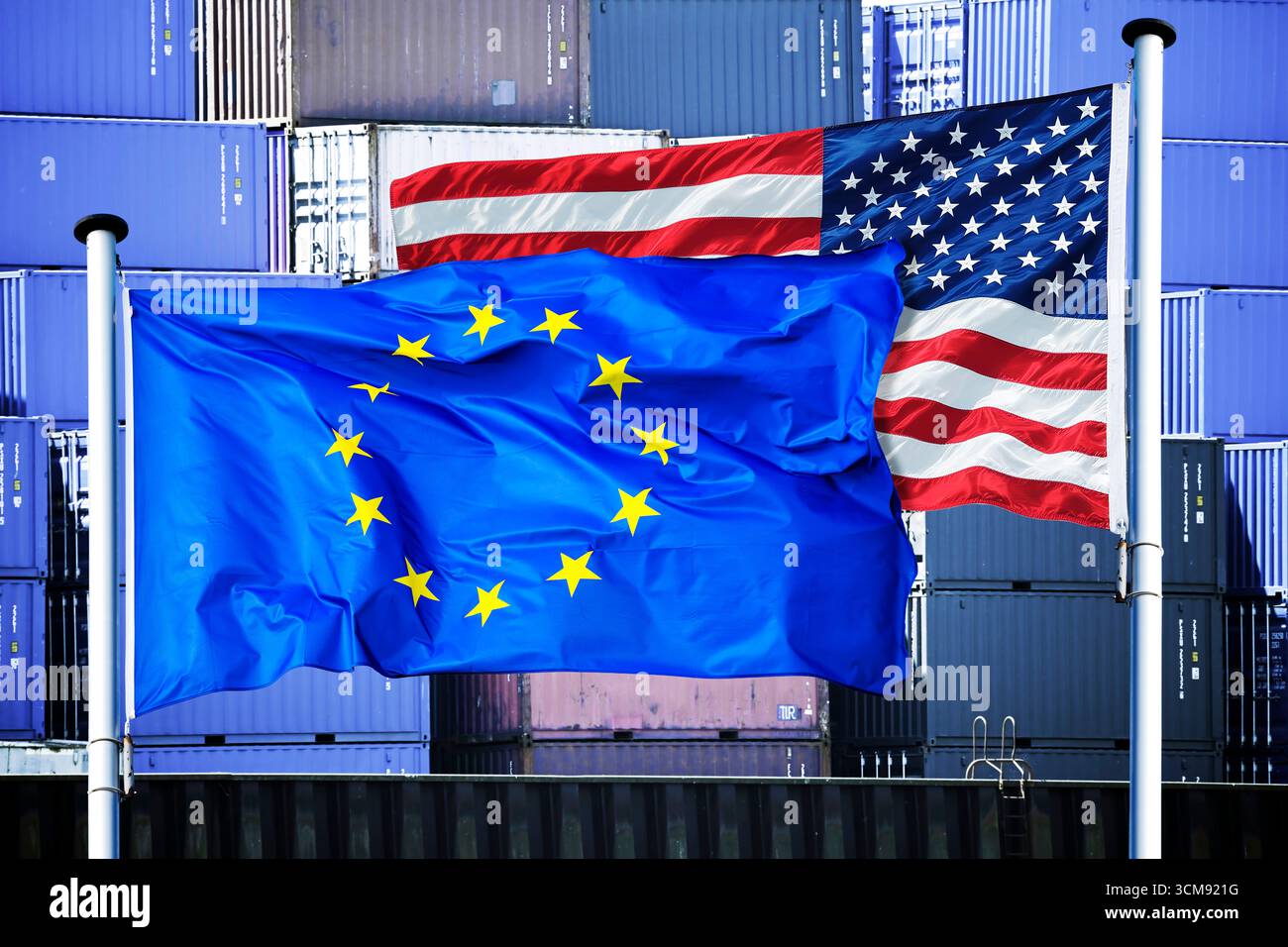 Symbolizing global trade tensions, the EU and U.S. flags flutter together against a sea of shipping containers, as economic disputes like Trump's Greenland tariffs escalate.