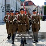 Polish troops march in formation through the historic streets of Warsaw, symbolizing national pride and the strength of NATO's eastern flank.