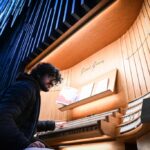 A musician performs on a grand organ, highlighting the cultural and musical heritage that may complement the Czech Republic’s pioneering approach to organ donation and public health policy.